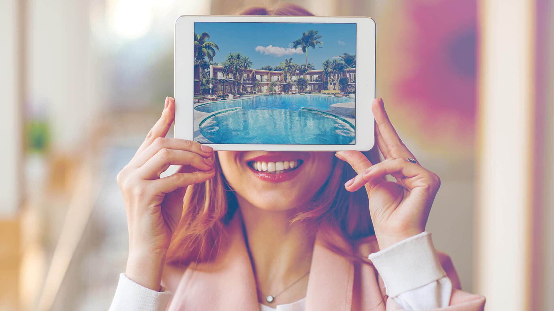 Agente immobiliare sorridente mostra su tablet rendering 3D di resort con piscina e palme per un annuncio di vendita immobiliare — ADDING Studios