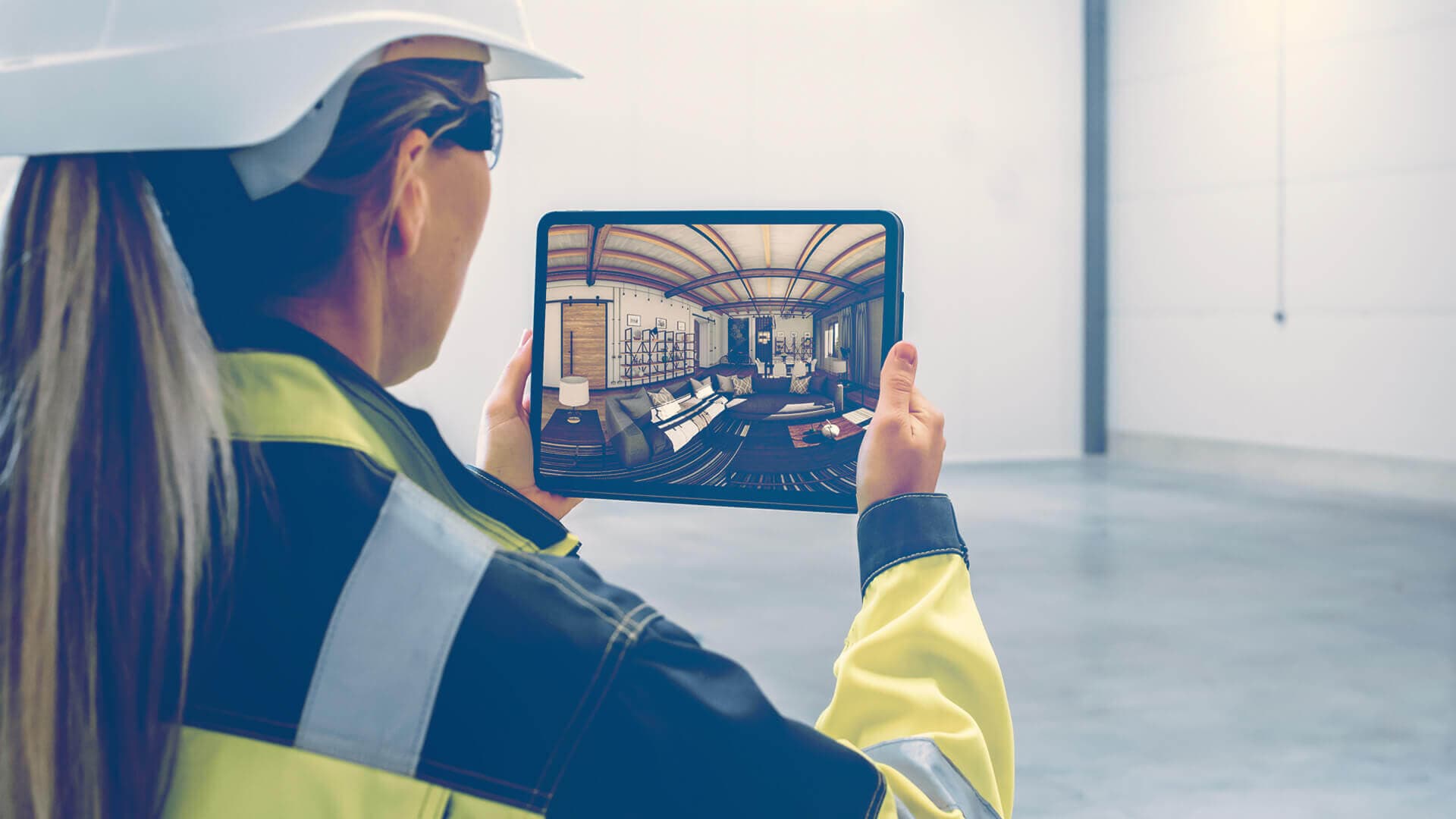 Operaia di impresa edile con casco di sicurezza e giubbotto ad alta visibilità visualizza rendering 3D interior fotorealistico su tablet in cantiere — ADDING Studios